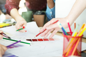Designer team working on color palette for project with colorful pencils.